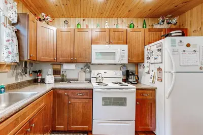 a kitchen with wooden cabinets and white appliances at Secluded Sanctuary in West Wardsboro