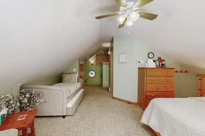 a attic bedroom with a bed and a ceiling fan at Secluded Sanctuary in West Wardsboro