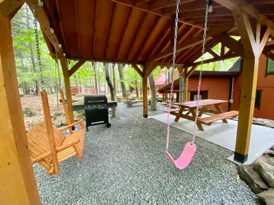 a porch with a swing and a picnic table at Lakeview Cabin in The Hideout in Lake Ariel