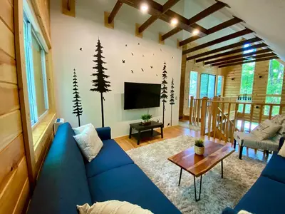 a living room with a blue couch and a tv at Lakeview Cabin in The Hideout in Lake Ariel