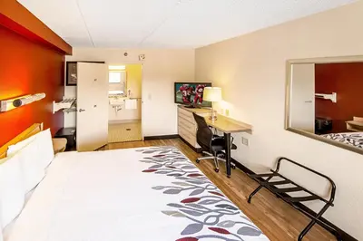a hotel room with a bed and a desk at Red Roof Inn Utica in Utica
