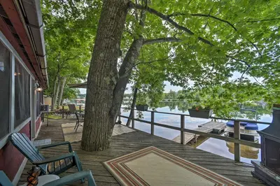 a deck with chairs and a tree and water at Riverfront Escape with Dock 19 Mi to Saratoga! in Lake Luzerne