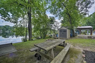 a picnic table and a shed in a park at Riverfront Escape with Dock 19 Mi to Saratoga! in Lake Luzerne