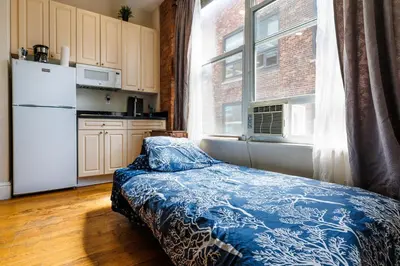 a kitchen with a bed in front of a window at Studios in New York in New York