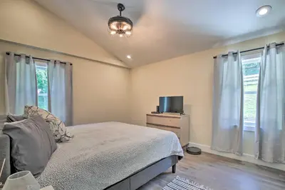 a bedroom with a bed and a tv and windows at Modern NY Home with Views By Hudson Valley Hiking! in Hopewell Junction