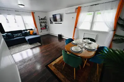 a living room with a table and chairs and a couch at Bright & cozy * 2nd Floor Apartment*. Close to NYC in Bloomfield