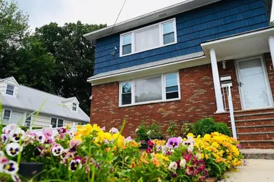 a house with flowers in front of it at Bright & cozy * 2nd Floor Apartment*. Close to NYC in Bloomfield