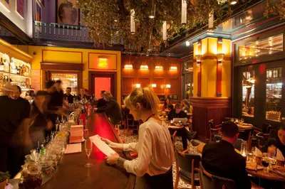 a woman standing at a bar in a restaurant at The Standard - East Village in New York