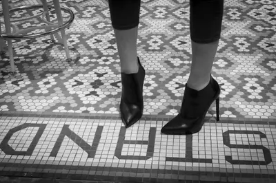 a woman wearing black heels on a tiled floor with the word sale at The Standard - East Village in New York