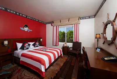 a red bedroom with a bed and a desk and a window at LEGOLAND New York Resort in Goshen