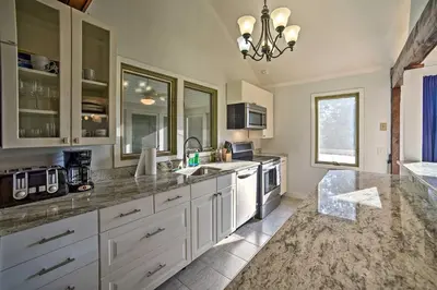 a large kitchen with white cabinets and a sink at Modern Catskills Reprieve with Hot Tub and Mtn Views! in Margaretville