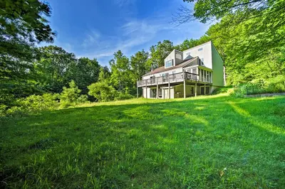 a house on a hill with a green yard at Modern Catskills Reprieve with Hot Tub and Mtn Views! in Margaretville