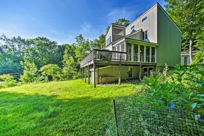 a green house on a hill with a yard at Modern Catskills Reprieve with Hot Tub and Mtn Views! in Margaretville