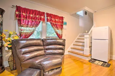 a leather chair in a living room with a staircase at Charming Yonkers Retreat - 10 Mi to Central Park! in Yonkers