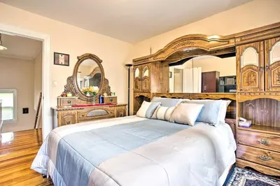 a bedroom with a large bed with a wooden headboard at Charming Yonkers Retreat - 10 Mi to Central Park! in Yonkers