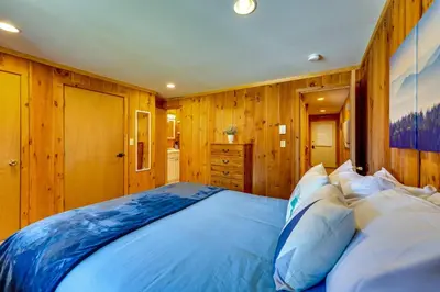 a large bed in a room with wooden walls at Relaxing Mountain Refuge 4 Miles to Mt Snow! in Dover