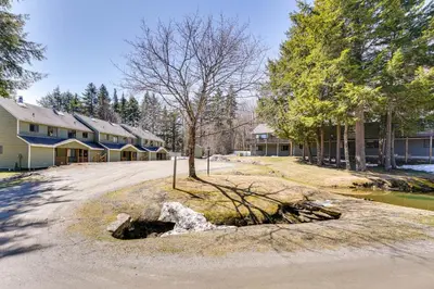 a tree in the middle of a road next to a house at Relaxing Mountain Refuge 4 Miles to Mt Snow! in Dover
