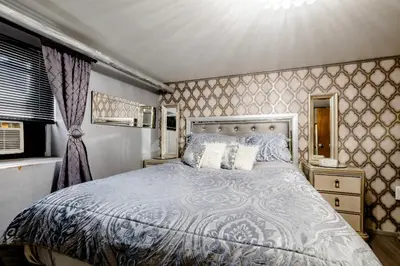 a bedroom with a bed with a blue comforter at Nice Cozy Room By Empire City Casino And Cross County Mall in Yonkers