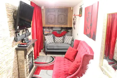 a living room with a red couch and a television at Nice Cozy Room By Empire City Casino And Cross County Mall in Yonkers