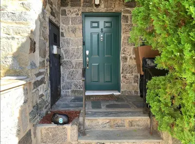 a green door on a stone house with a cat next to it at Nice Cozy Room By Empire City Casino And Cross County Mall in Yonkers