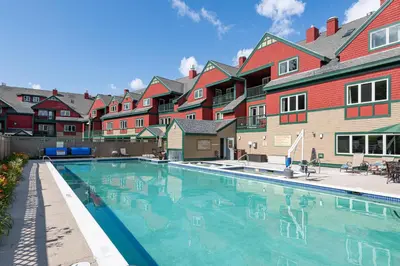 a swimming pool in front of a row of houses at Grand Summit Resort, A Vail Resorts Property in Dover