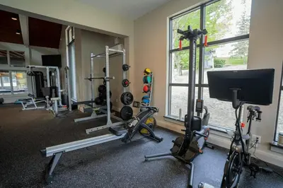 a gym with several treadmills and bikes in a room at Mount Snow Lodging by Vail Resorts in Dover