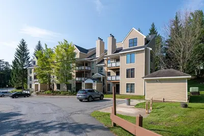 a house with a car parked in front of a street at Mount Snow Lodging by Vail Resorts in Dover