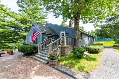 a blue house with an american flag on it at Mount Snow Lodging by Vail Resorts in Dover