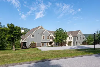 a large house with a driveway and grass at Mount Snow Lodging by Vail Resorts in Dover