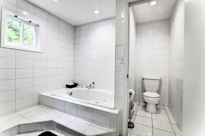 a white bathroom with a tub and a toilet at Game Room! Poconos Paradise 10 Mi to Ski Slopes in East Stroudsburg