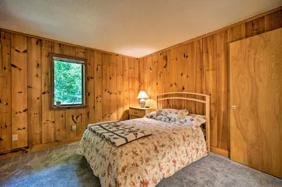 a bedroom with wooden walls and a bed and a window at Spacious Dover Home with Sauna Less Than 5 Miles to Ski! in Dover