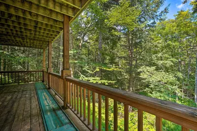 a porch of a cabin with a view of the woods at Spacious Dover Home with Sauna Less Than 5 Miles to Ski! in Dover