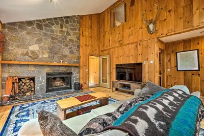 a living room with a couch and a stone fireplace at Spacious Dover Home with Sauna Less Than 5 Miles to Ski! in Dover