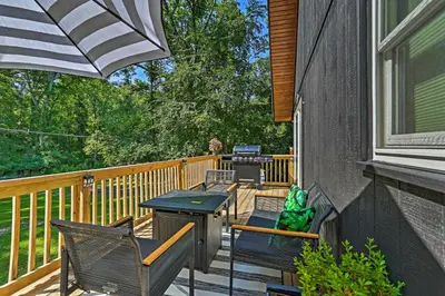 a deck with two chairs and a table and an umbrella at Deck and Gas Grill Modern East Stroudsburg Home! in East Stroudsburg