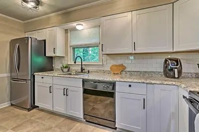 a kitchen with white cabinets and a stainless steel refrigerator at Deck and Gas Grill Modern East Stroudsburg Home! in East Stroudsburg