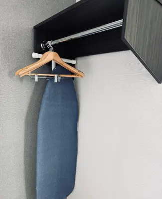 a blue tie is hanging on a hanger at Capital Hotel Long Island City in Queens