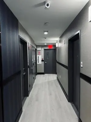 a hallway with black doors and a hallway with a corridorngthngthngthngthngth at Capital Hotel Long Island City in Queens