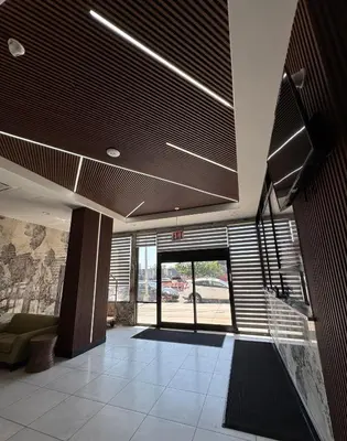 an office lobby with a large glass door with blinds at Capital Hotel Long Island City in Queens