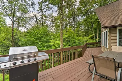 a barbecue on a deck with a table and a grill at Steps to River Big Bass Lake House with Grill! in Gouldsboro