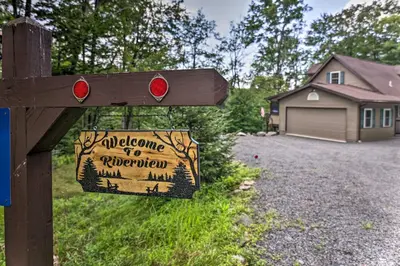 a wooden sign with a welcome to northwestern sign in a yard at Steps to River Big Bass Lake House with Grill! in Gouldsboro