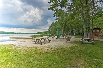 a park with benches and a playground next to a lake at Steps to River Big Bass Lake House with Grill! in Gouldsboro