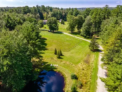 an aerial view of a field with a pond at Southwoods Mountain Estate -private mansion, pool, hottub+ 15 acres in Monticello