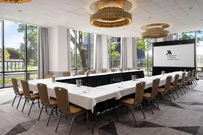 a long table in a room with chairs and a screen at Teaneck Marriott at Glenpointe in Teaneck