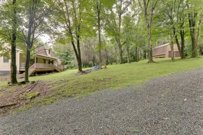 an empty road in front of a house with trees at 2 Mi to Elk Mountain Poconos Escape on 11 Acres! in Pleasant Mount