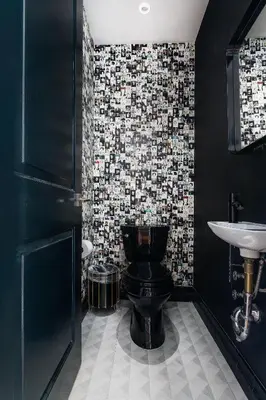 a bathroom with a black toilet and a sink at Placemakr Wall Street in New York