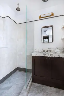 a bathroom with a sink and a glass shower at Placemakr Wall Street in New York