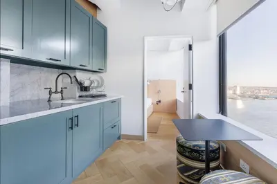 a kitchen with blue cabinets and a sink at Placemakr Wall Street in New York