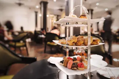 a three tiered plate of pastries on a table at The Pierre, A Taj Hotel, New York in New York