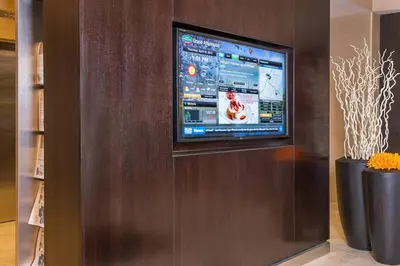 a flat screen tv on a wall in a room at Courtyard by Marriott Secaucus Meadowlands in Secaucus