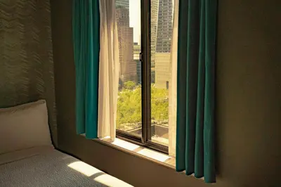 a bedroom with a window with green curtains at The Cloud One New York-Downtown, by the Motel One Group in New York